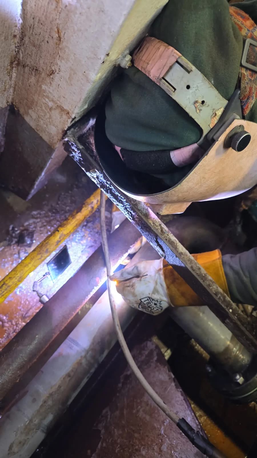 Close-up of a welder at work under a hood